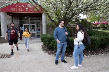 Students talking near and walking out of Donovan 餐厅 Hall